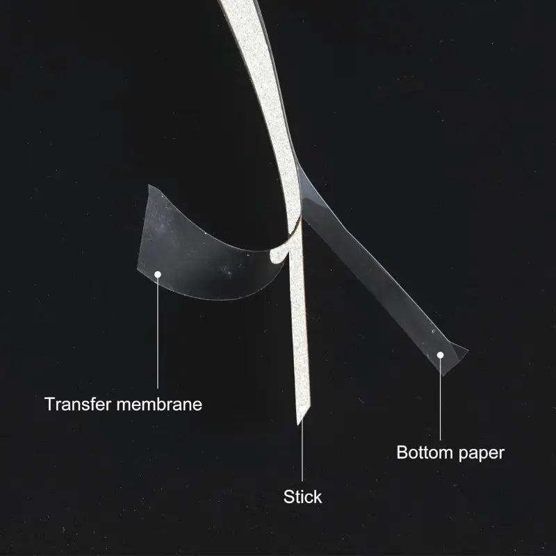 Bâtonnet de transfert scintillant argenté avec membrane transparente et papier inférieur pour application temporaire sous forme de tatouage, illustré dans un lot d’autocollants vinyle rayés pour rétroviseurs de voiture.