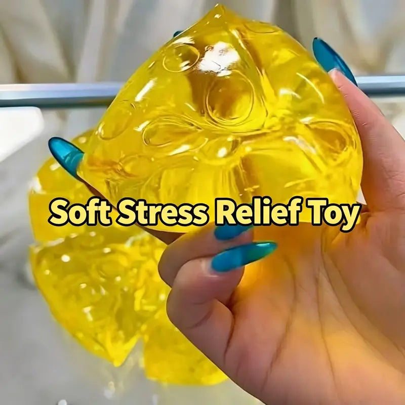 a translucent yellow mini triangle cheese fidget toy made of soft gelatinous material with a glossy, squishy texture and bubble-like indentations for stress relief and squeezing.