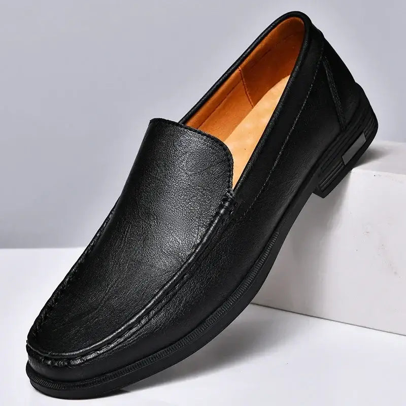Men genuine leather slip-on dress loafers in black with tan interior lining and subtle stitching details.