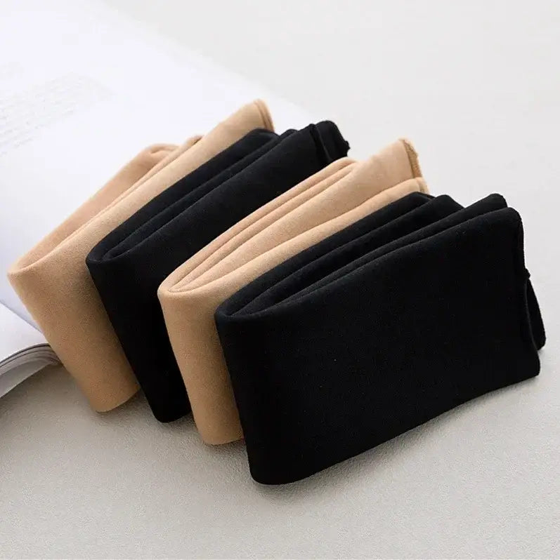 a pair of black and beige winter thermal socks made from cashmere wool with a soft smooth fleece lined fabric texture displayed folded