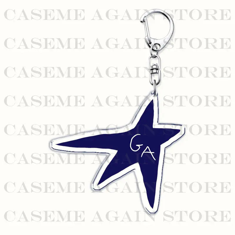 A navy blue acrylic star-shaped keychain with a silver outline and ga initials in white attached to a metallic clasp designed as a Gracie Abrams anime fan gift.