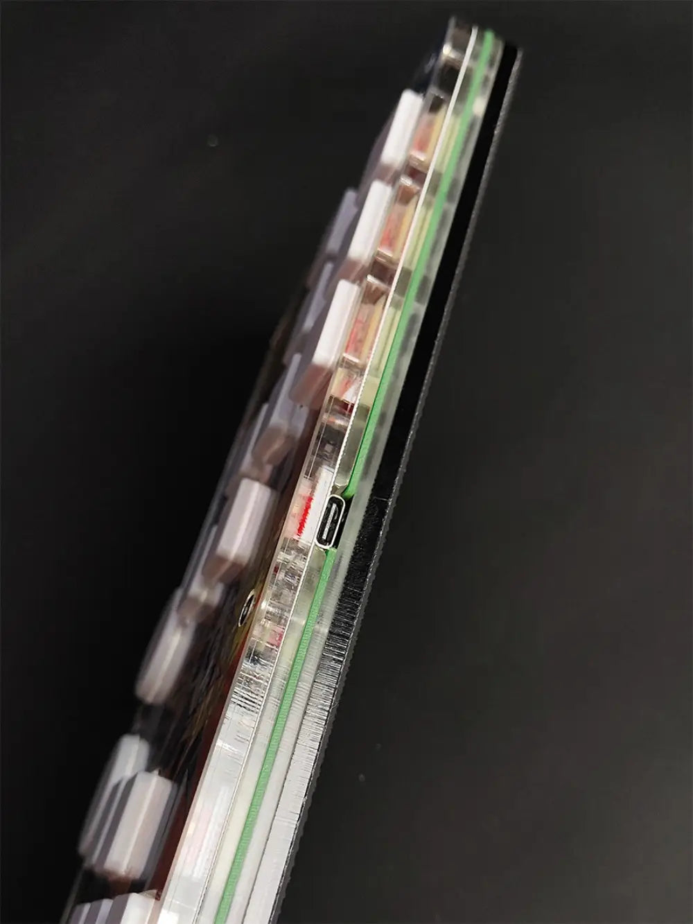 Transparent plastic case of djmax mechanical gaming keyboard showing internal circuitry and usb-c data cable port with left joystick support for joystick moves.