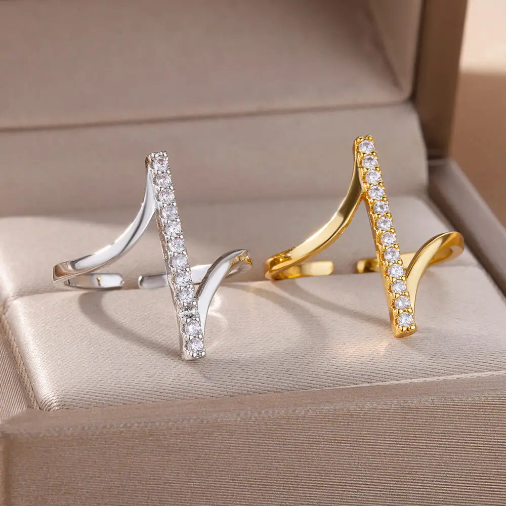 a pair of elegant zircon geometric rings for women featuring open-ended sleek v-shaped design with rows of sparkling clear crystals set in gold color stainless steel and silver-toned metal.