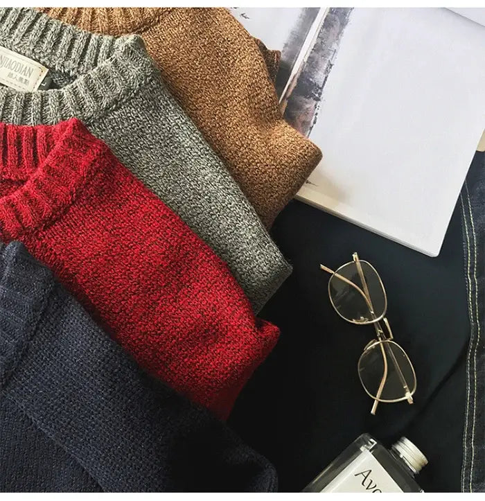 présentés dans une disposition confortable : quatre pulls en laine pour homme surdimensionnés, en maille décontractée, en rouge, gris, marron et bleu marine, avec encolures côtelées et tissu en laine texturée.