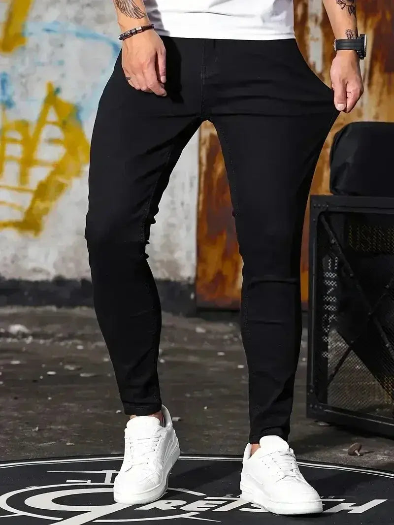 Jeans en denim bleu foncé coupe slim pour homme présentant un design moderne et élégant, avec des détails de coutures subtils et une silhouette épurée.