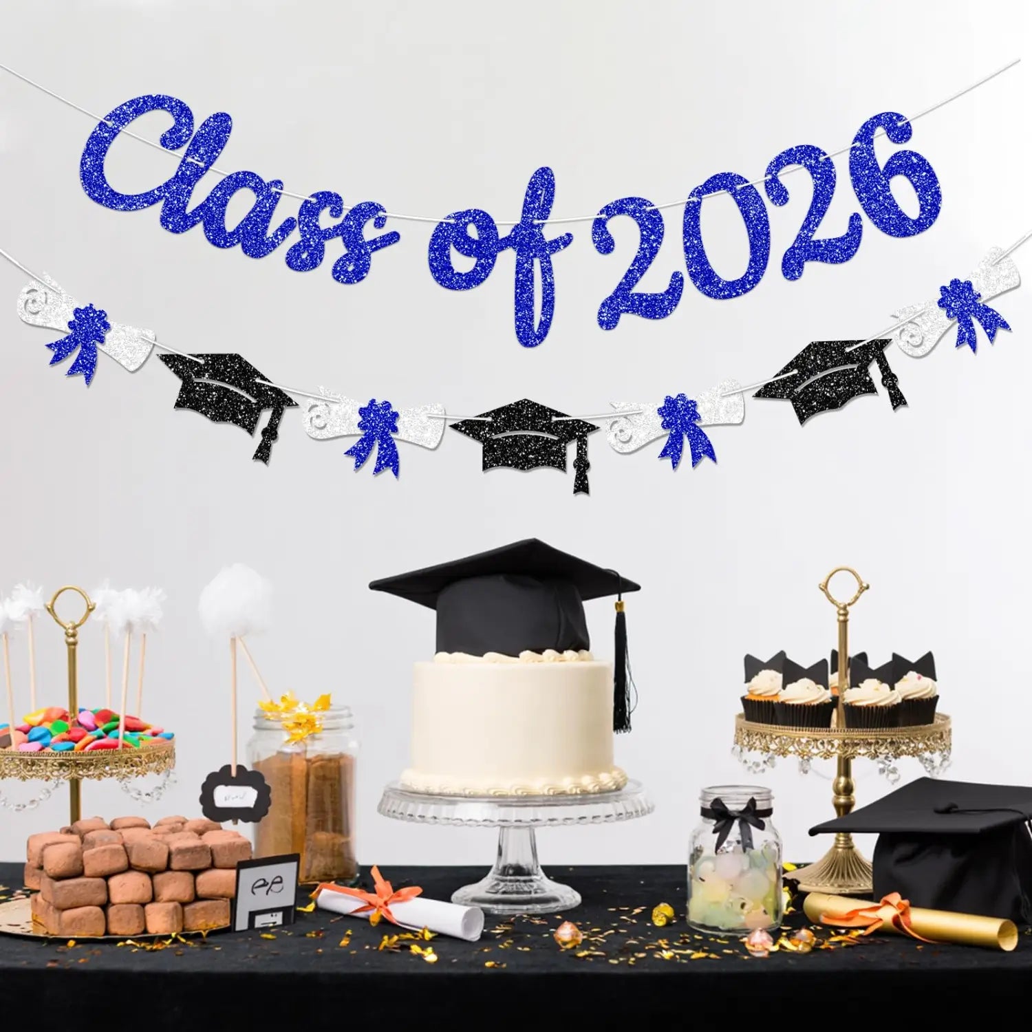 A glittery blue and black class of 2026 graduation banner and garland featuring caps and tassels for celebration decor.