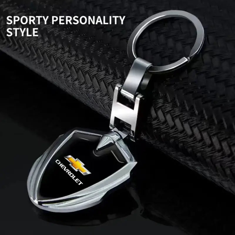 Silver Chevrolet metal shield car keychain with a black shield-shaped pendant and chrome finish.