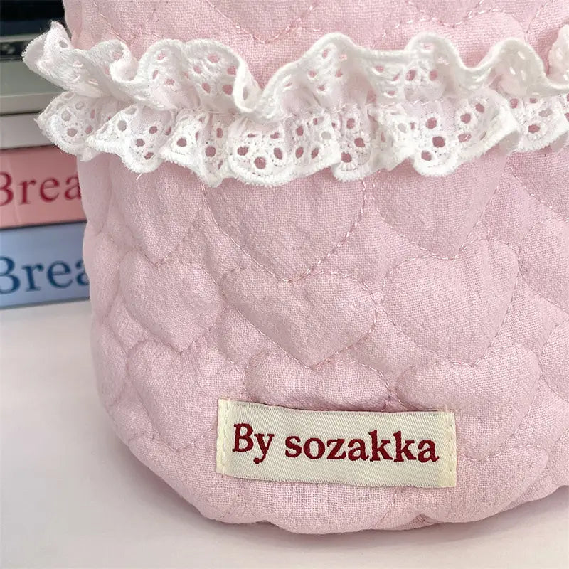 Rosa gepolsterter Aufbewahrungskorb für das Kinderzimmer mit Spitzenbesatz, der eine Stoff-Haartrocknerhülle im passenden rosa gepolsterten Material und weißem Spitzenbesatz umfasst