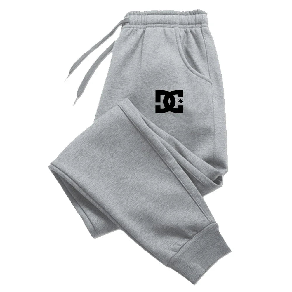 Graue Dc Shoes Herren-Jogginghosen, legere Sweatpants, mit schwarzem Logo auf dem linken Oberschenkel, für Komfort und legere Kleidung gestaltet.
