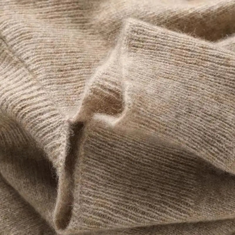 ein weicher beiger Strickschal, Cardigan oder Wickel aus Wolle aus Kaschmir mit gerippter Struktur und dezenten natürlichen Fasern
