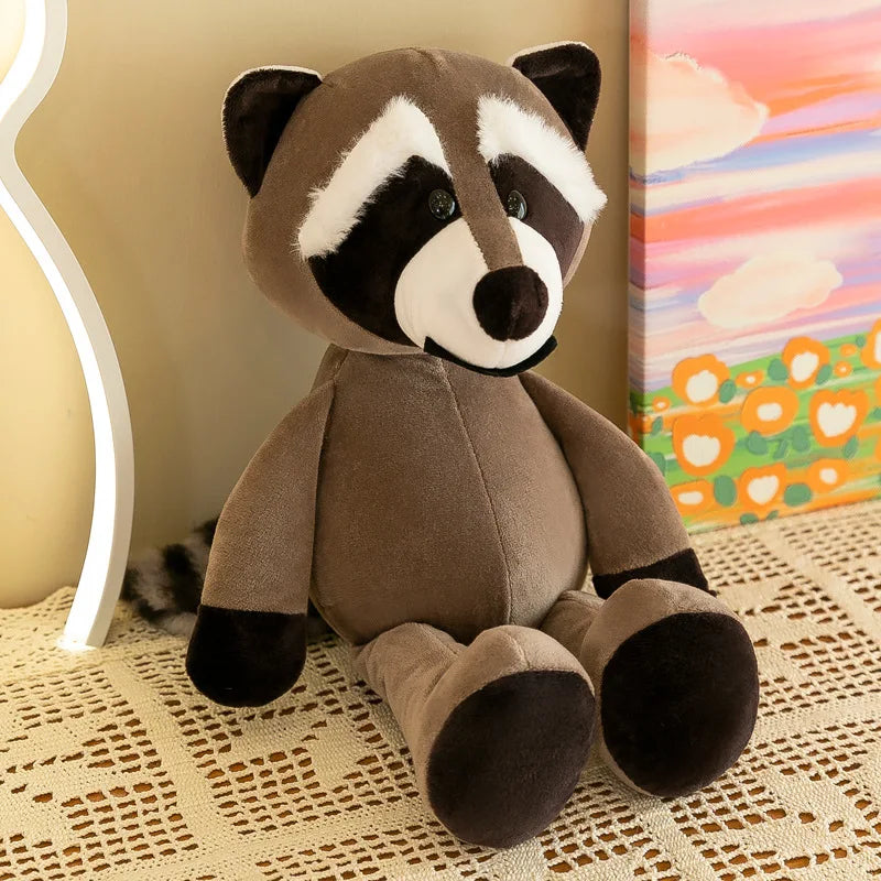 Un peluche de animal de la jungla con un mapache marrón de terciopelo suave, con marcas faciales negras y blancas y una cola a rayas.