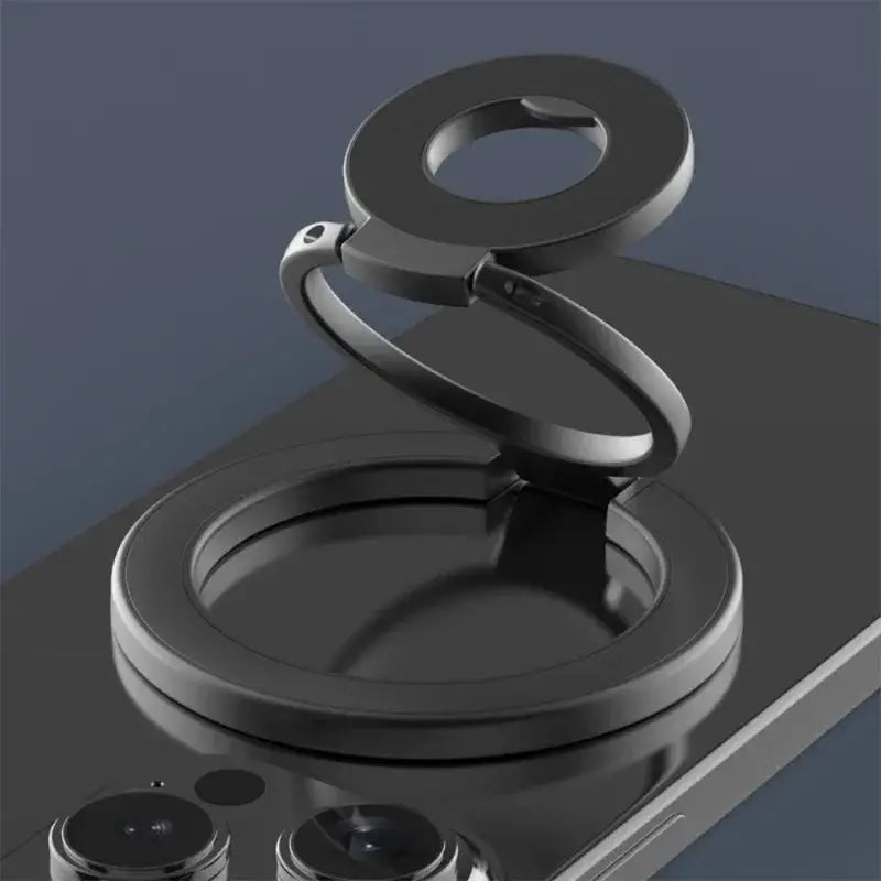 Anillo portateléfonos magnético de doble cara metálico negro con diseño en espiral y base circular visto desde el frente.