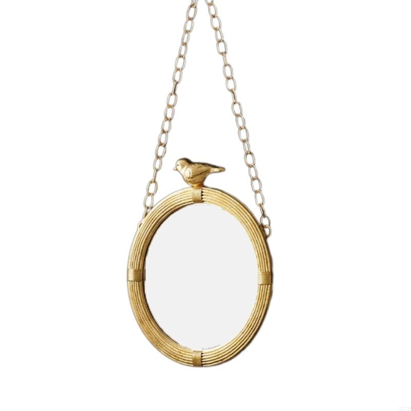 Miroir décoratif à la finition dorée, à monture en résine comportant un motif en rotin tressé, avec une petite figurine d’oiseau, suspendue par une chaînette assortie, pour une décoration murale intérieure.