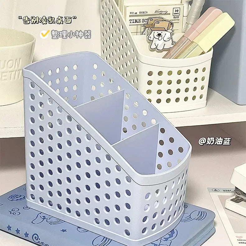 Light blue plastic desktop stationery organizer with a perforated design and three compartments for makeup and pen storage.