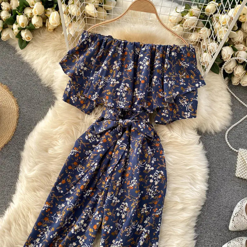 Enterizo de pierna ancha con estampado floral azul marino, escote tipo bardot, mangas con volante y cinturilla atada confeccionada con tejido ligero para un uso casual elegante.