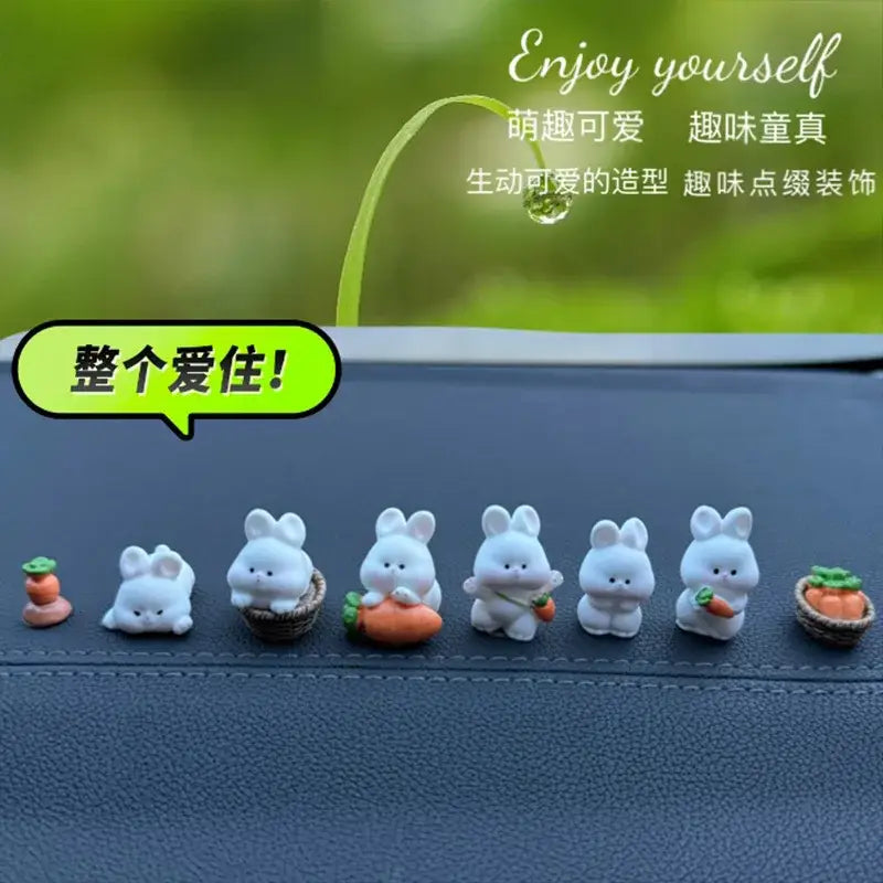 Une rangée de six adorables ornements de tableau de bord de voiture en forme de lapin blanc, avec des poses variées et de petits accessoires de carotte orange.