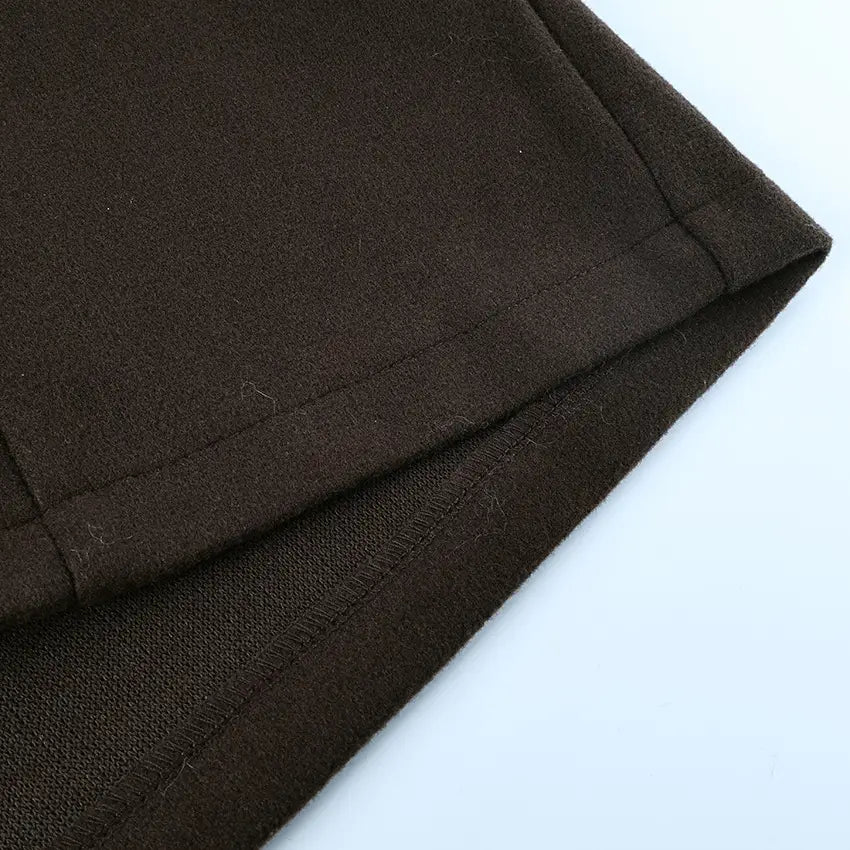 dark brown soft-textured wool fabric with neat stitching along the hem on a belted winter coat.