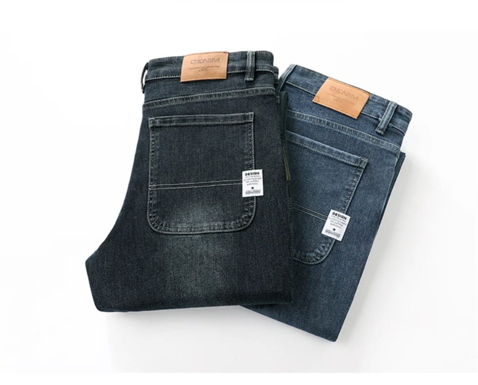 Men’s loose straight business casual jeans in dark-wash denim featuring a classic five-pocket design and brown leather brand patches.
