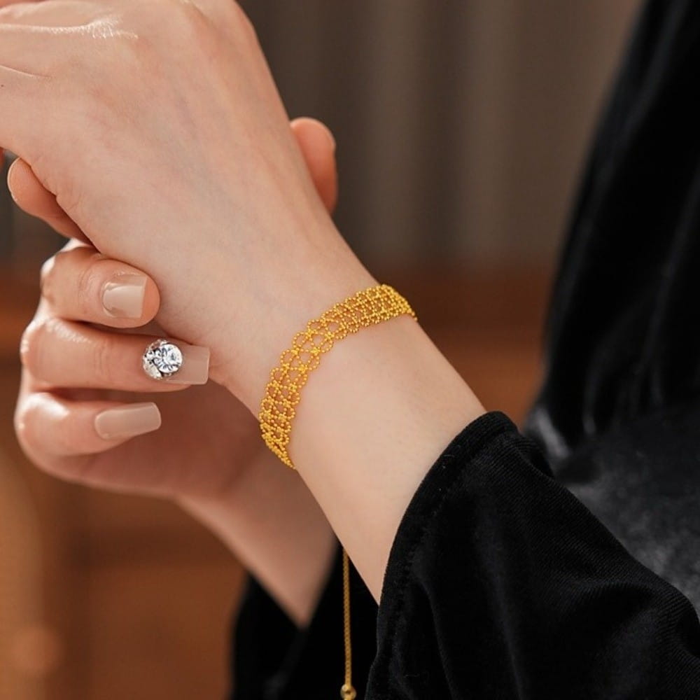 A delicate multi-strand gold mesh metal lace bracelet adjustable fashion jewelry adorning a wrist.