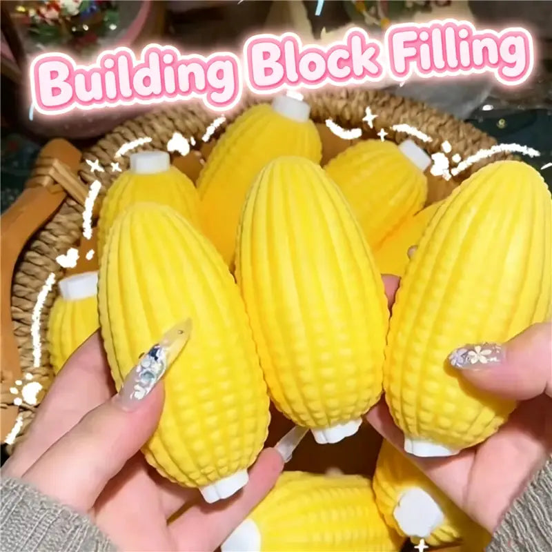 Jouets sensoriels de type balle anti-stress en forme d’arachide en forme de maïs, jaune, avec des capuchons blancs et des grains texturés conçus comme accessoires de soulagement du stress