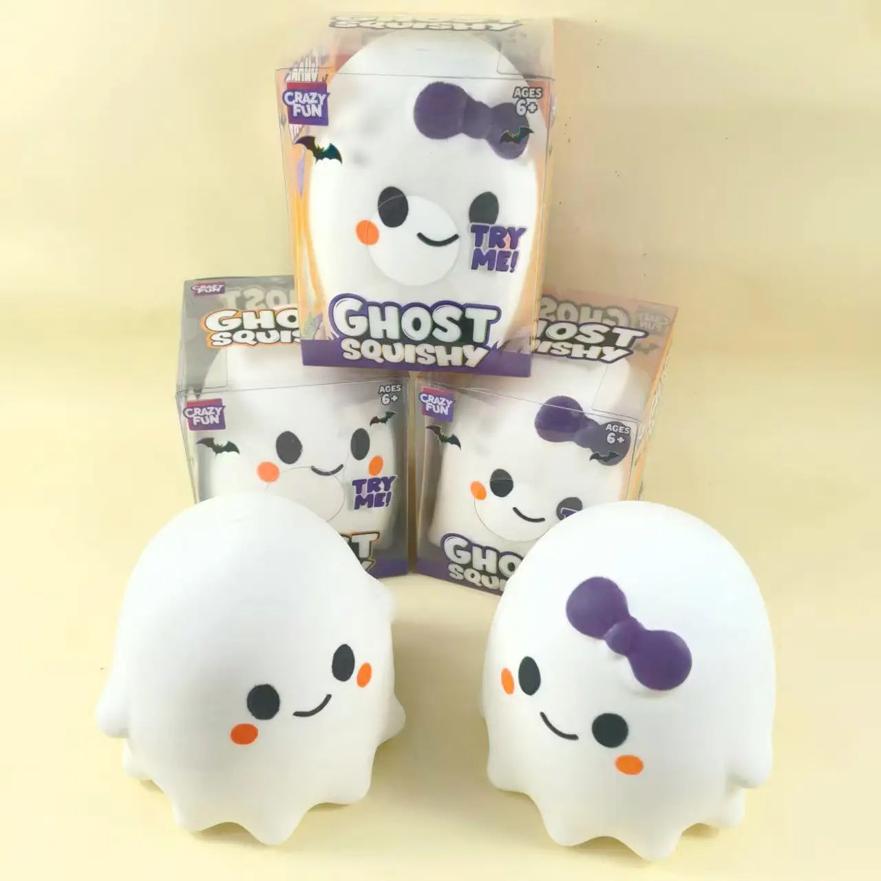 White ghost-shaped squishy slow rising stress relief toy with black eyes orange cheeks and a purple bow on one version made of soft material.