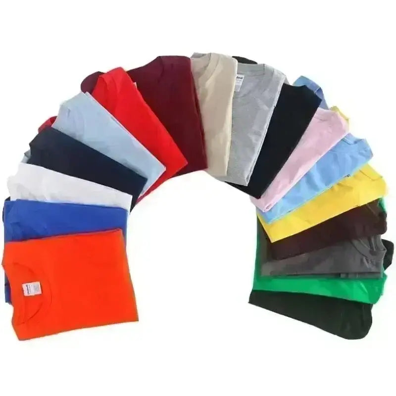 Un conjunto vibrante de camisetas deportivas de verano unisex dobladas con esmero en colores sólidos variados, incluidos rojo, azul, naranja, verde y negro, diseñado para una ropa deportiva cómoda.