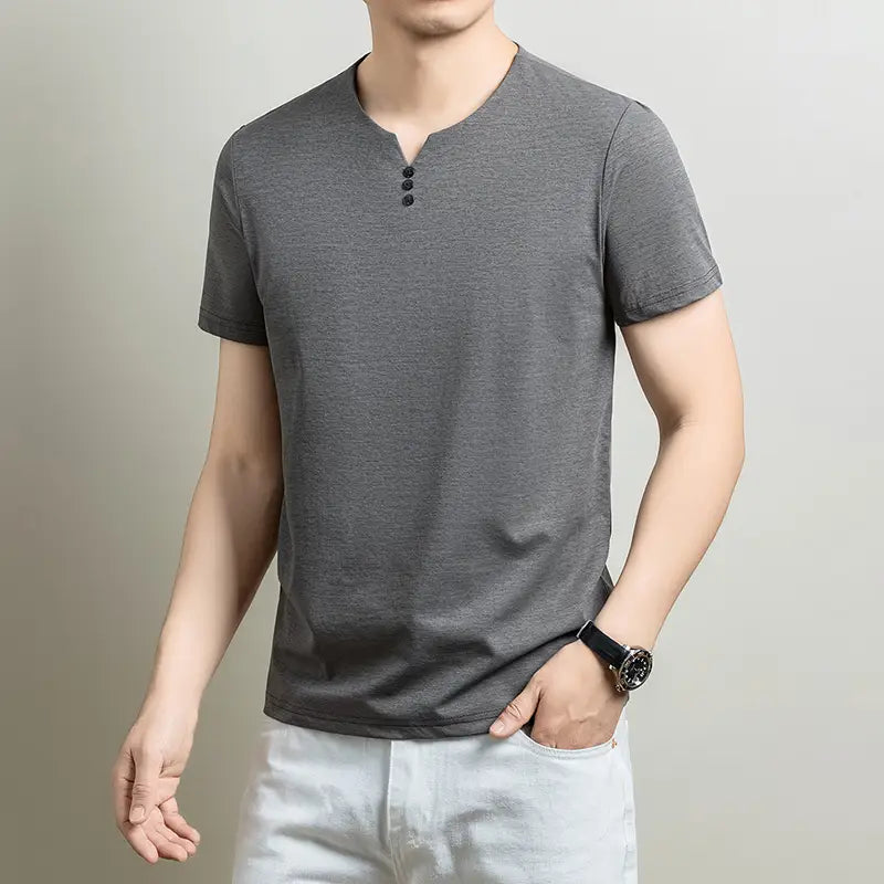 Camisa tipo henley para hombre de manga corta en tejido gris con textura, con tres botones negros en el cuello, para uso casual.