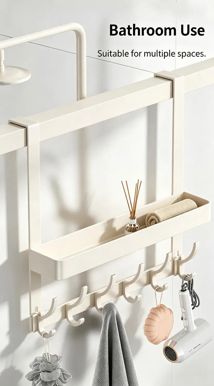 Off-white over door organizer with shelf and multiple hooks made of metal holding towels hairdryer and bath accessories.