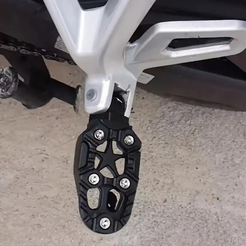 Black cnc aluminum motorcycle footpeg with star-shaped cutout pattern and silver bolts designed as rear anti slip pedals.