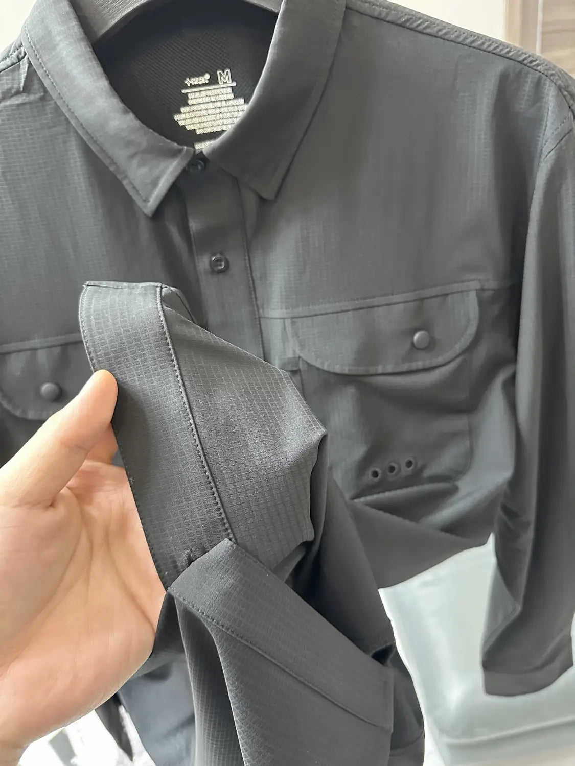 Men’s tactical outdoor long sleeve shirt in dark gray with a subtle textured weave and two chest pockets.