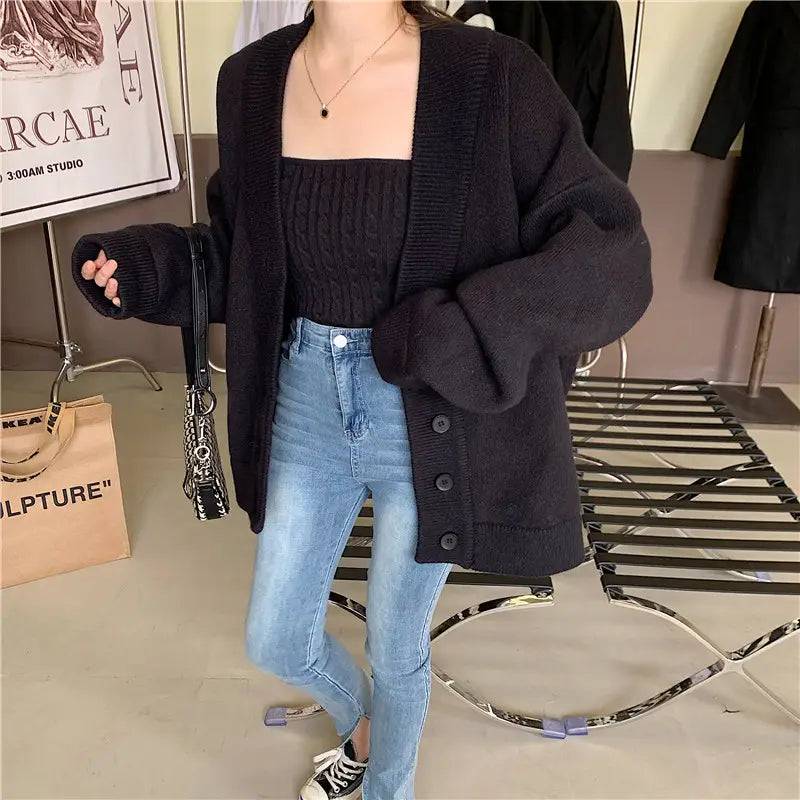 Schwarze Oversize-Strickjacke mit Knopfverschluss und gerippten Bündchen aus dem stilvollen Retro-Wickelbrust-Strick-Set aus zwei Teilen.