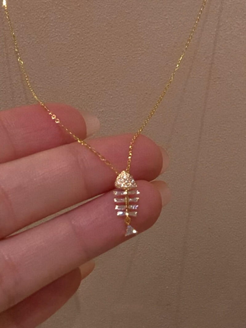 A delicate gold chain necklace featuring a fish-shaped pendant adorned with clear sparkling stones from the Crystal Fishbone Gold Necklace Pendant Jewelry collection.