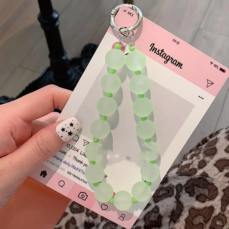 Eine zarte mintgrüne Perlen-Handy-Handgelenksschlaufe mit kleinen grünen Spacer-Perlen und einem silberfarbenen Karabinerclip ist als mehrfarbige Charm-Handgelenksschlaufe gestaltet.
