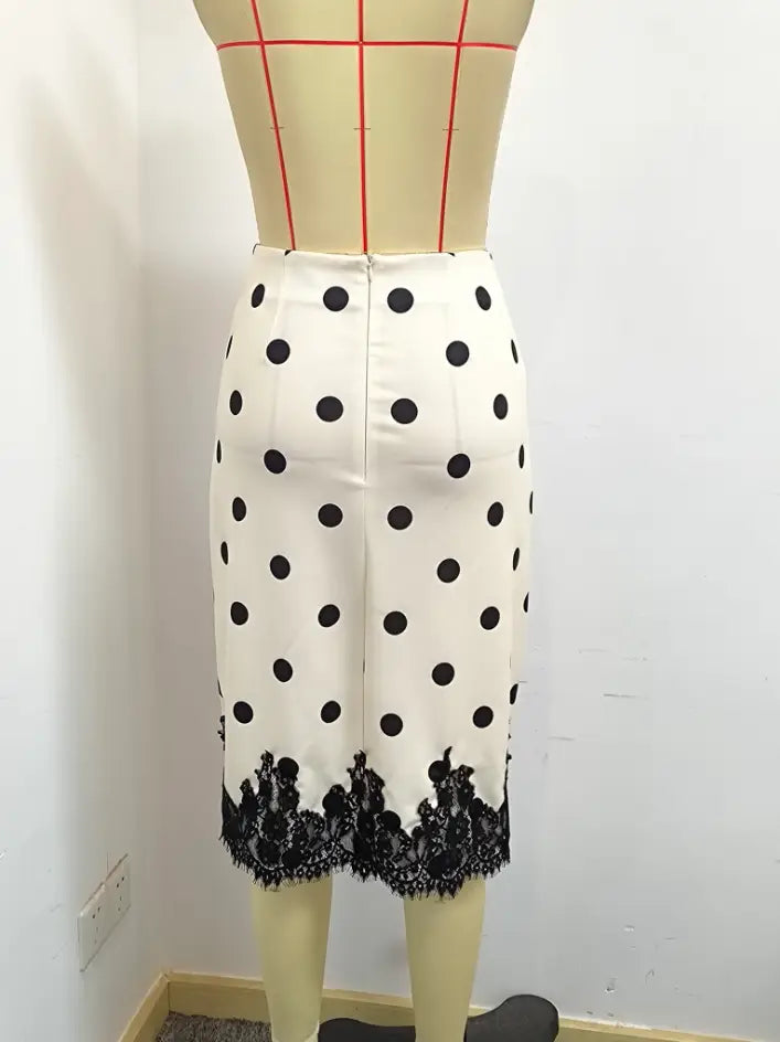 Una falda midi de lunares con encaje en blanco que presenta lunares negros y un ribete de encaje negro en el dobladillo.