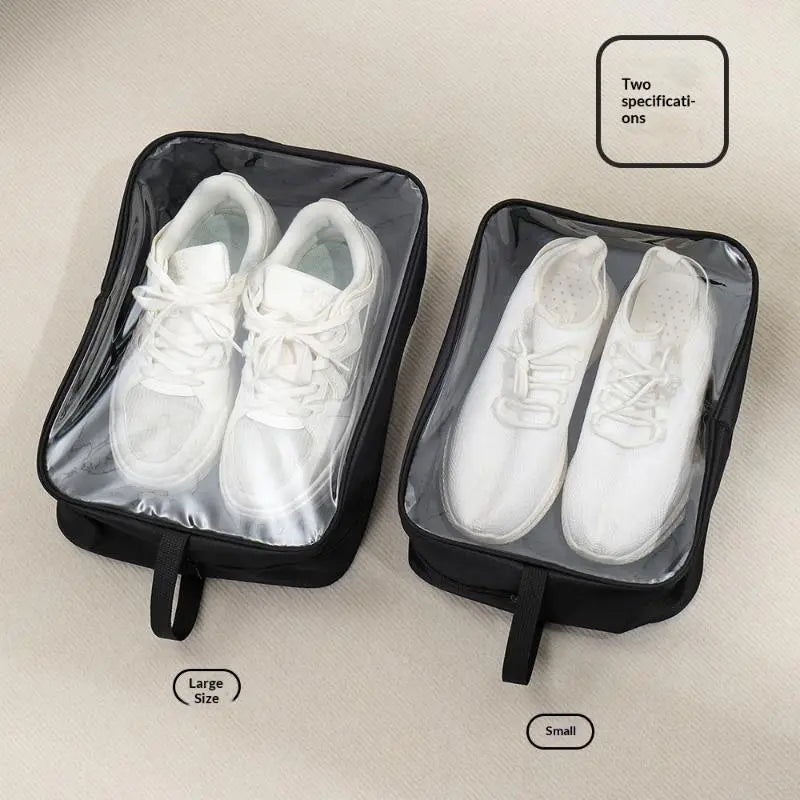 Sacs de voyage imperméables noirs pour chaussures avec fermeture à glissière et panneaux frontaux transparents, chacun contenant une paire de baskets blanches pour un rangement organisé.
