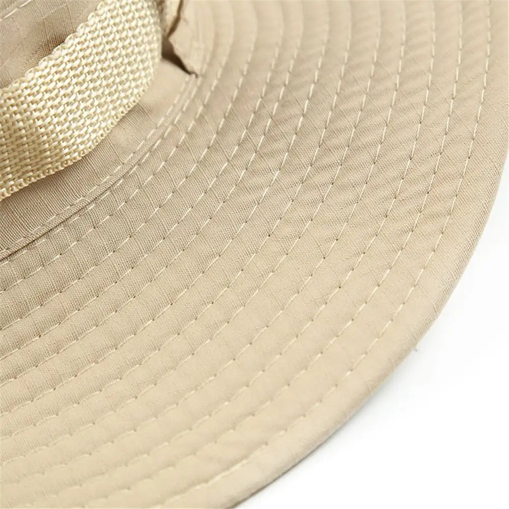 Sombrero tipo cubo de pescador de ala ancha en tejido beige tejido, con visera texturizada y correa ajustable para protección solar en verano