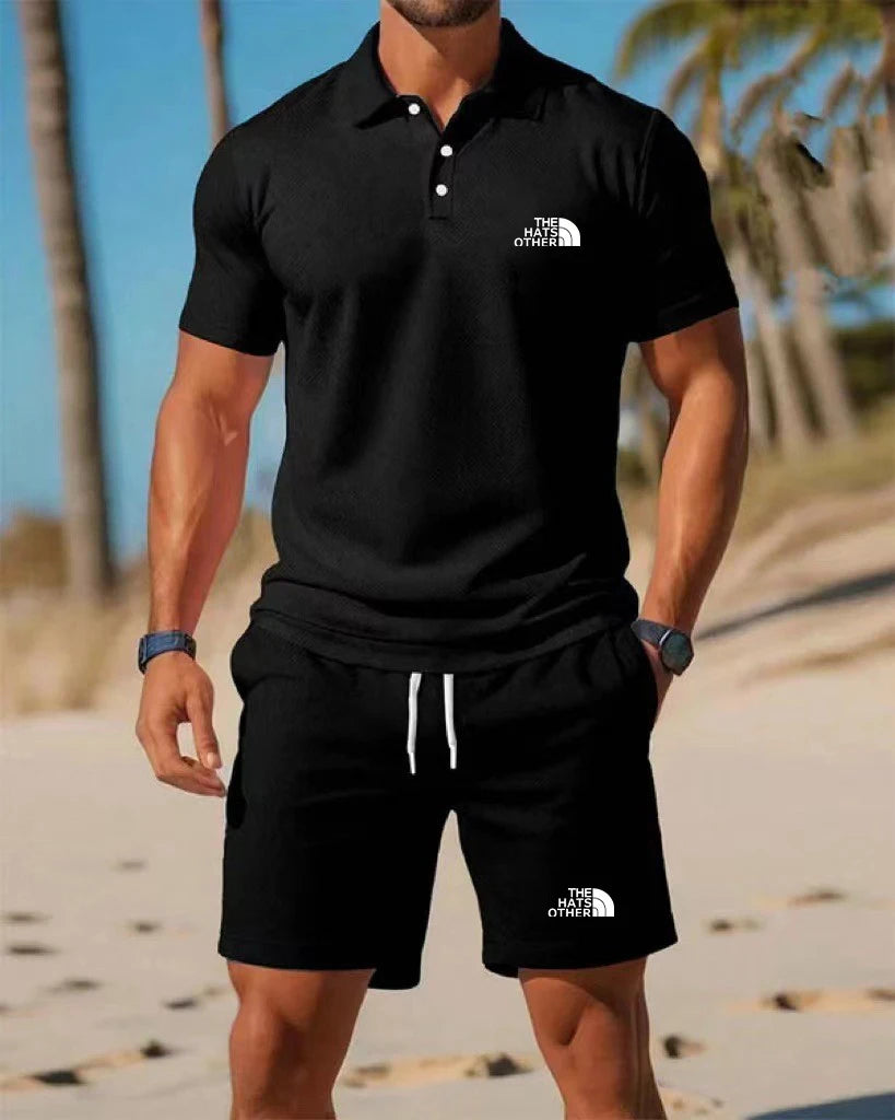 Men’s knit polo and shorts set featuring a black short-sleeved polo shirt with a white button placket and embroidered logo on the chest.