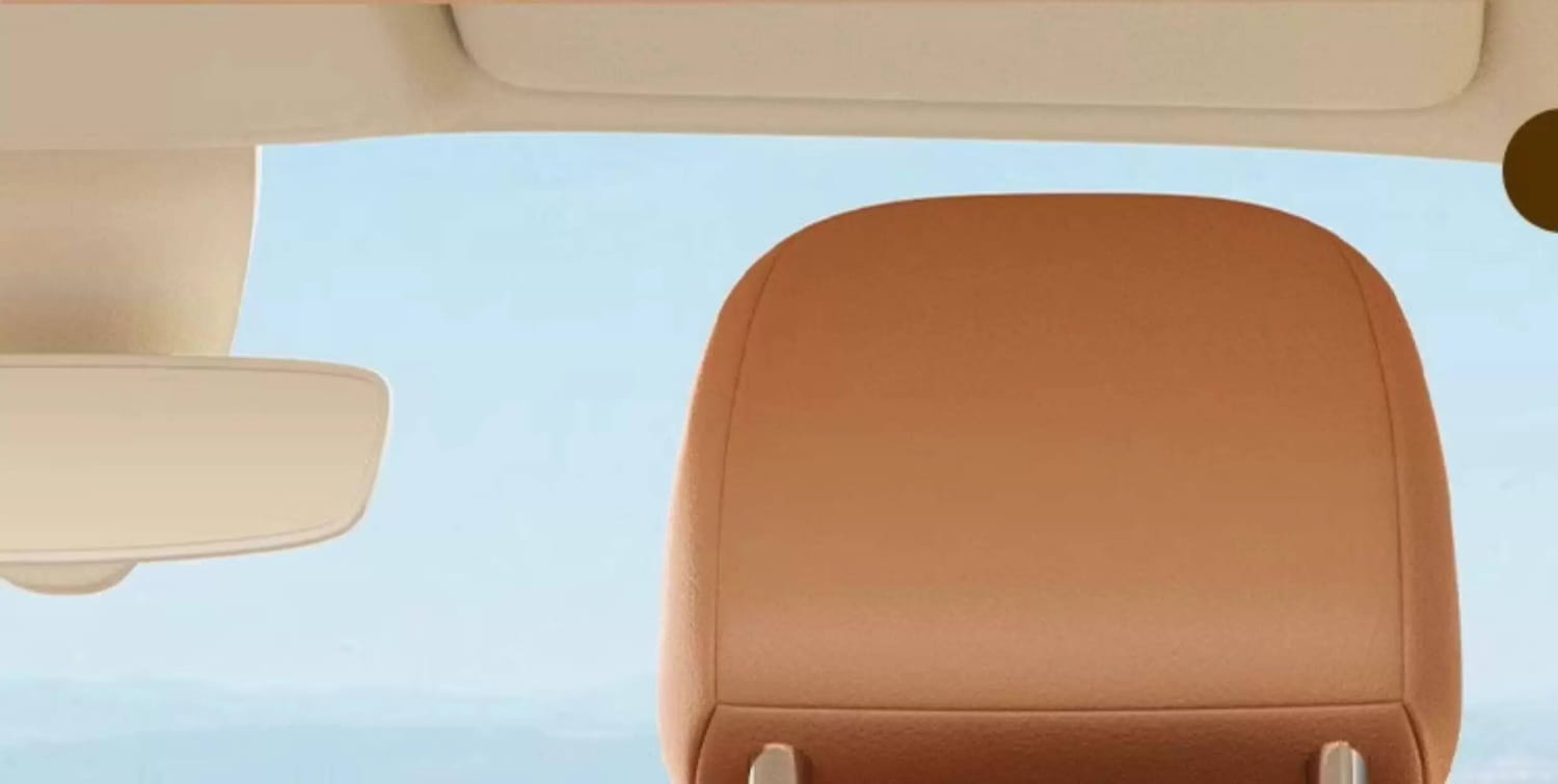 Tan leather car headrest featuring the back side of the car seat organizer animal alphabet storage pocket with multiple storage compartments.