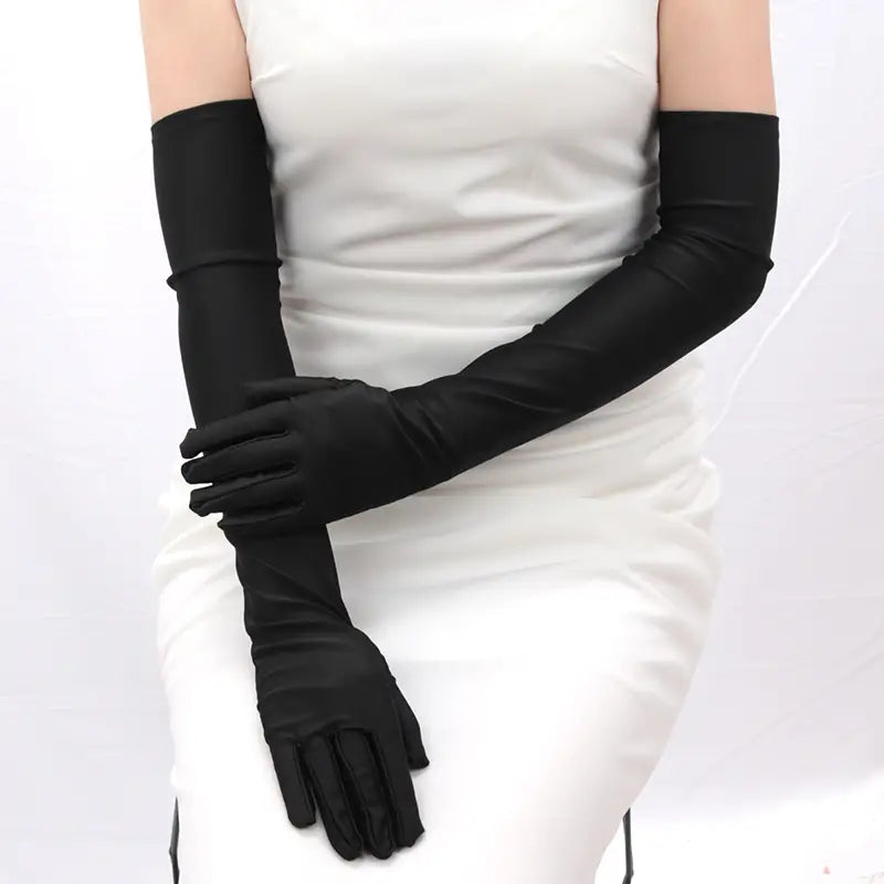 Guantes largos de ópera de satén negro para mujer mostrados desde el lado posterior, exhibiendo su textura lisa y elegante.