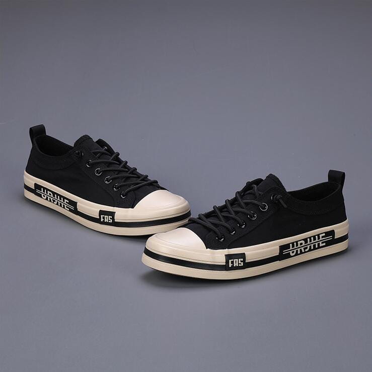Baskets décontractées en toile pour hommes, chaussures d’été légères en noir, avec des coques en caoutchouc et des semelles en blanc, comportant une inscription noire audacieuse sur le côté.