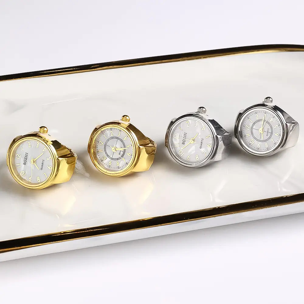 Four elegant boqiji brand ring watches in gold and silver finishes with white dials featuring black numerals and slender hands designed as unisex quartz finger jewelry gifts.
