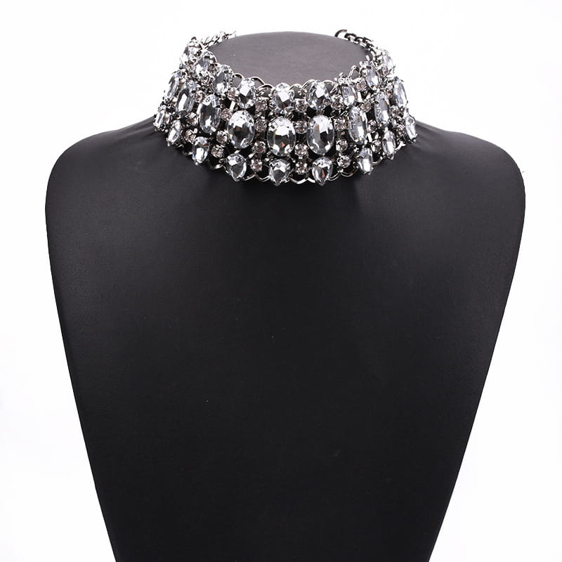 Un collier choker en strass cristal argenté étincelant, vendu en gros, comprenant plusieurs rangées de cristaux facettés transparents et des accents métalliques.