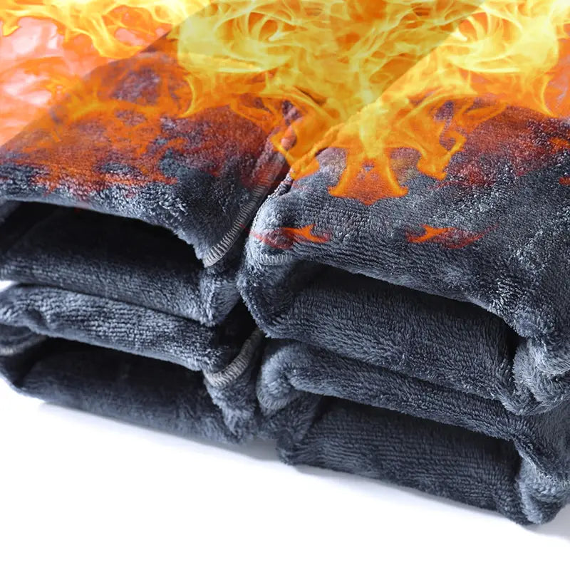 Jeans rétro délavés coupe droite ample pour hommes, portés en pantalon en molleton gris foncé superposé, avec un motif de flammes orange et rouge ardent sur la partie supérieure.
