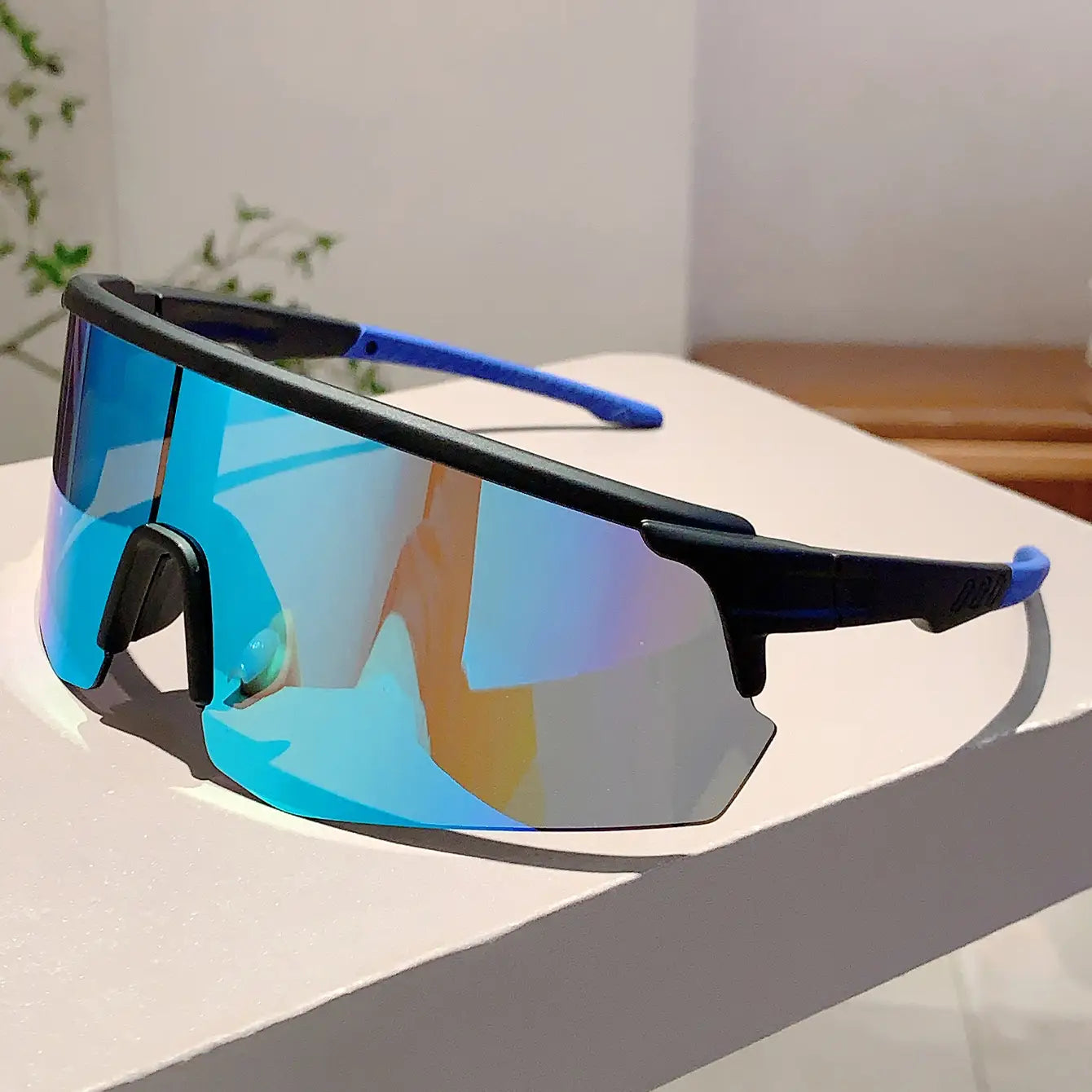 Lunettes de soleil de sport surdimensionnées avec montures bleues et noires et verres miroirs dégradés bleus réfléchissants, conçues pour le cyclisme.