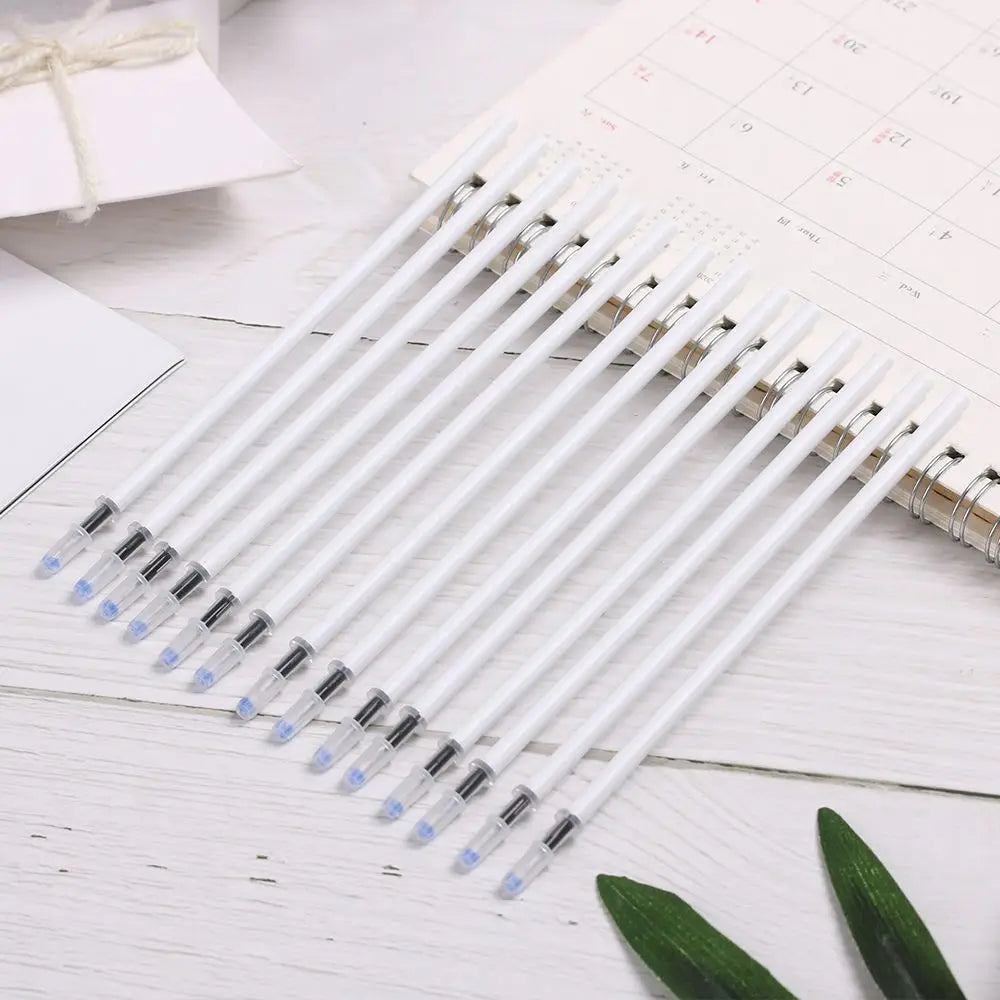 A set of gel pen refills with black ink featuring white gel pen bodies and transparent caps neatly arranged on a wooden surface.