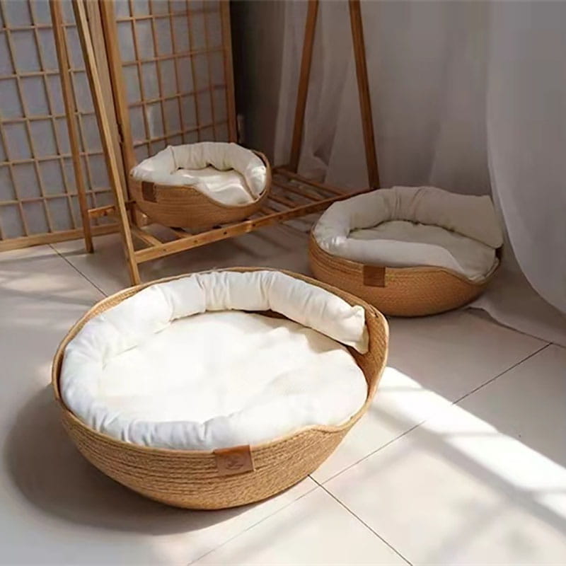 Cat bed paper rope woven sleeping bag made of woven wicker with a plush white cushion and soft interior lining for comfortable resting.