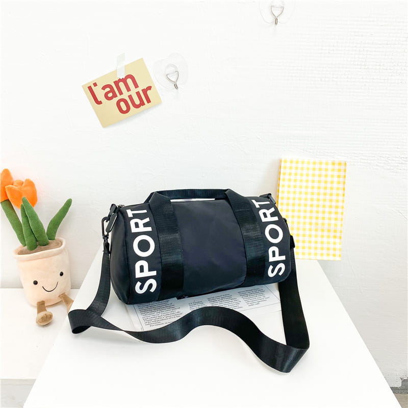 Schwarze zylindrische Kinder-Sport-Reise-Sporttasche mit kräftiger weißer Sportbeschriftung und verstellbarem Riemen für die Nutzung als Reise- und Crossbody-Gepäck