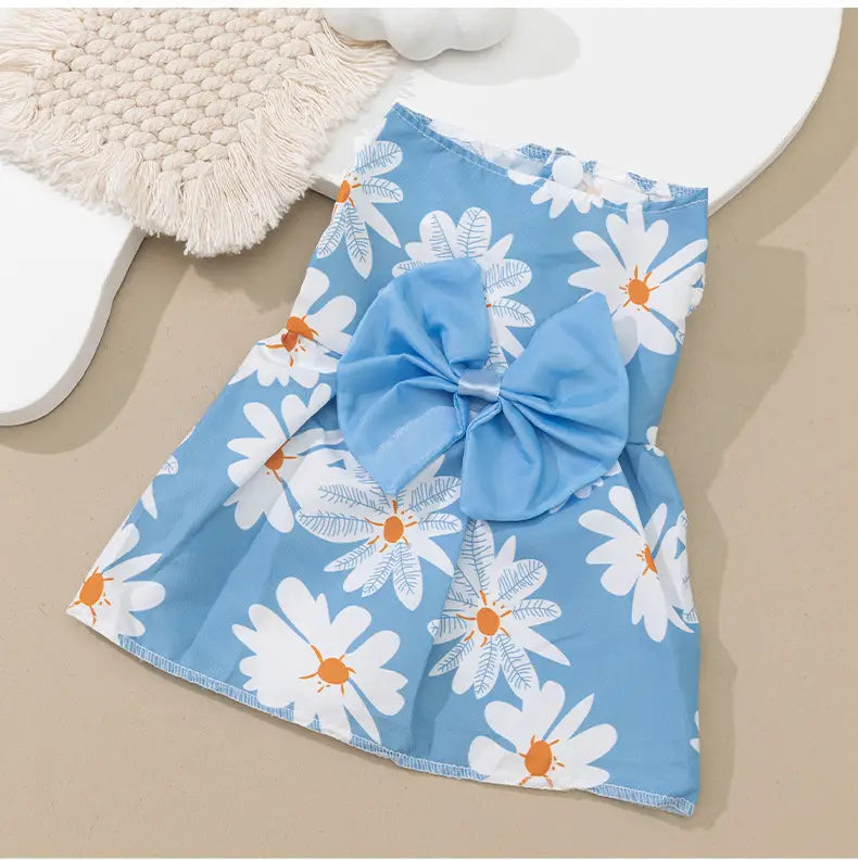 floral dog princess dress with bow featuring a light blue fabric adorned with white daisies with orange centers and a large matching bow at the front