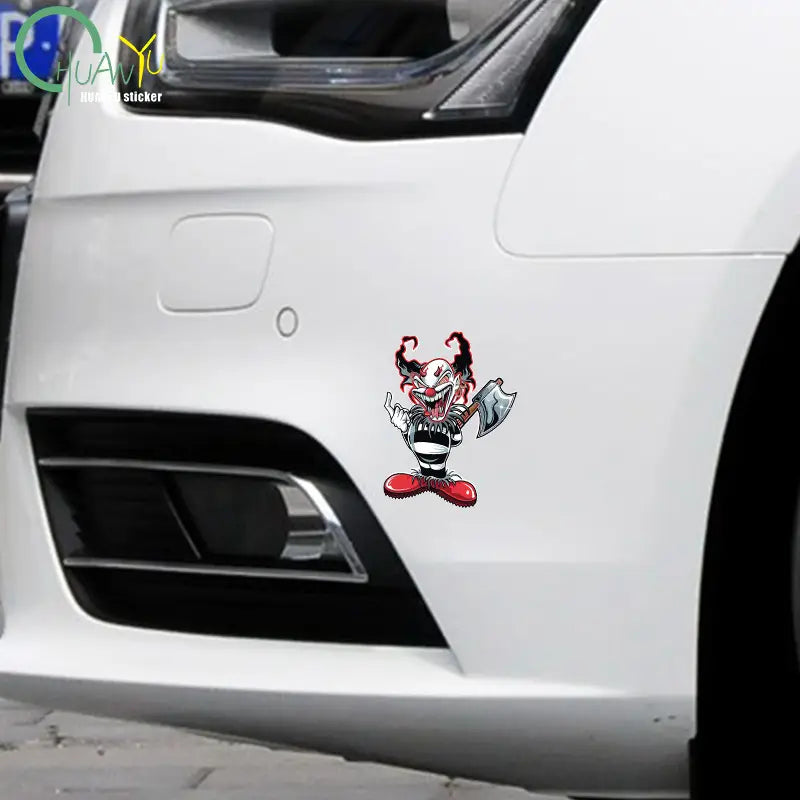 Autocollant de voiture imperméable de clown rouge et noir au style dessin animé portant une tenue rayée et tenant une hache.