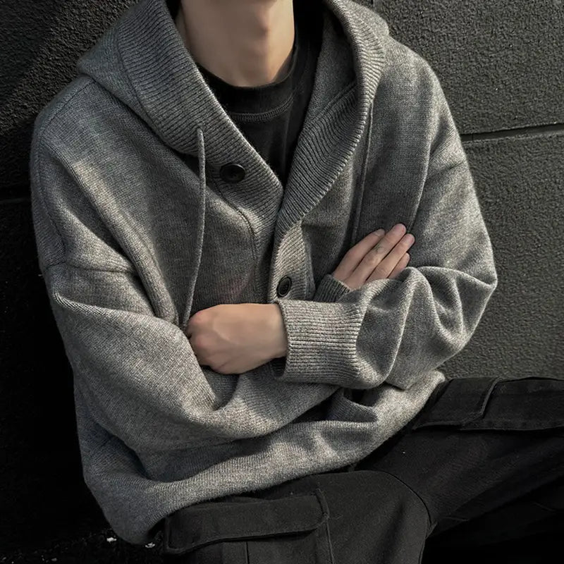 Herren-übergroßer Strickpullover mit Kapuze in Grau mit geripptem Kragen und Bündchen; mit drei dunklen Knöpfen mittig nach vorn für den Retro-Streetwear-Stil.